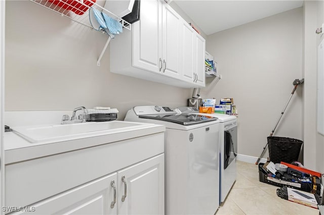 clothes washing area featuring cabinet space, light tile patterned floors, baseboards, washer and dryer, and a sink