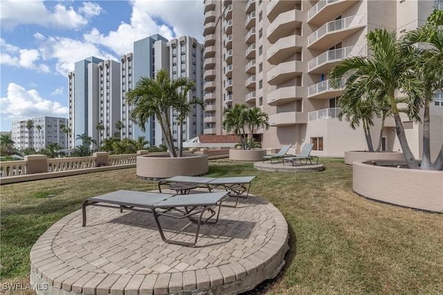 view of home's community featuring a lawn, a patio area, and a city view