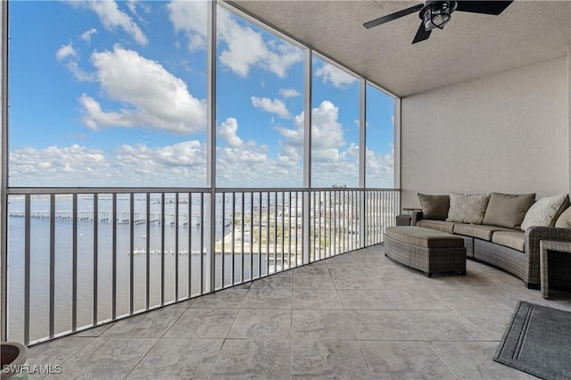 sunroom with a water view and ceiling fan