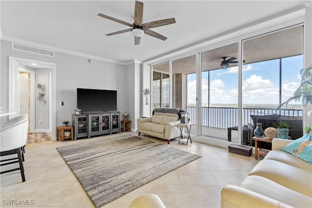 living room featuring ceiling fan, light tile patterned floors, visible vents, and crown molding