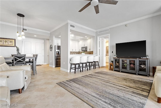 living room featuring ornamental molding, visible vents, and baseboards