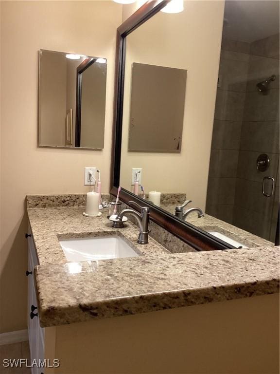 bathroom with vanity and a shower with shower door