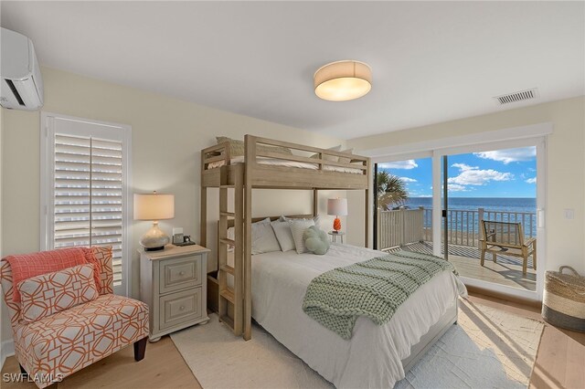 1 Sunset Captiva Ln, Captiva, FL 33924 - bedroom with a wall mounted AC, light wood-style floors, access to exterior, and a water view
