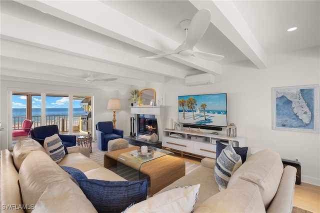 living room with beamed ceiling, ceiling fan, light hardwood / wood-style floors, and a wall unit AC