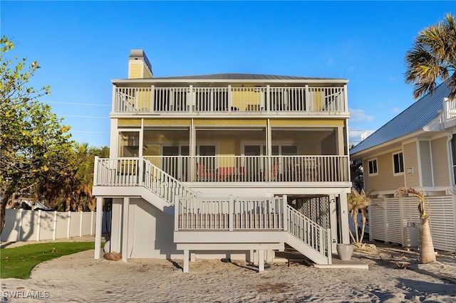 1 Sunset Captiva Ln, Captiva, FL 33924 - raised beach house featuring stairway, a balcony, a sunroom, and a chimney