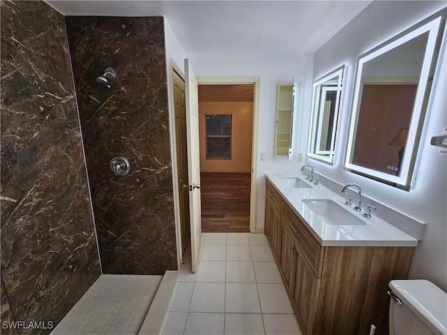 bathroom featuring vanity, tile patterned flooring, toilet, and tiled shower