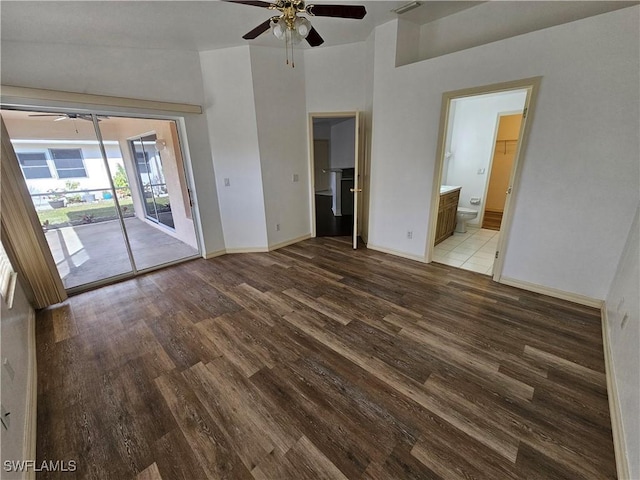 unfurnished living room featuring hardwood / wood-style flooring, ceiling fan, and a towering ceiling