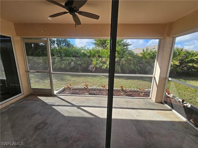 unfurnished sunroom with ceiling fan