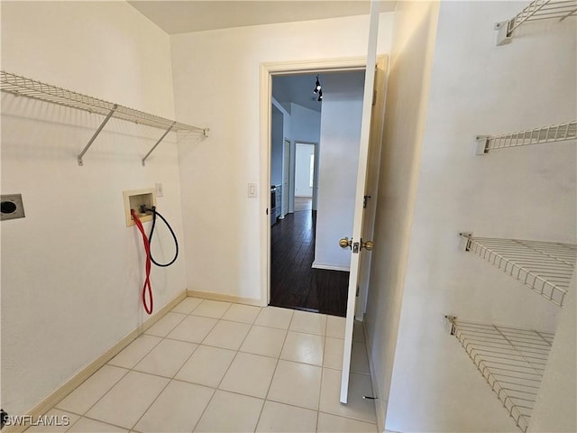 laundry room featuring electric dryer hookup, hookup for a washing machine, and light tile patterned floors