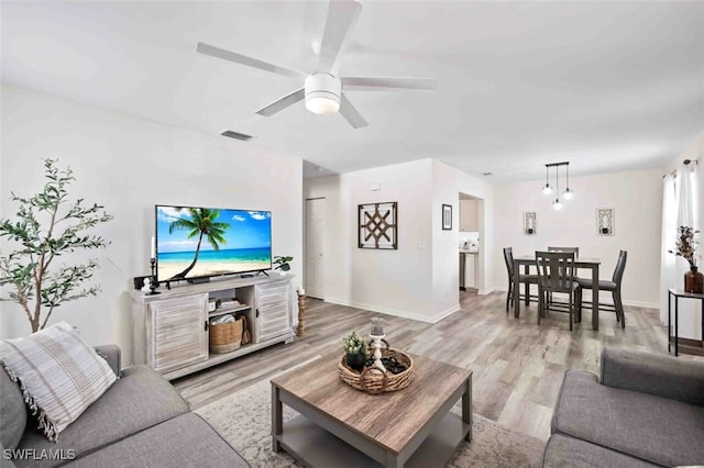 living room featuring ceiling fan and light hardwood / wood-style flooring