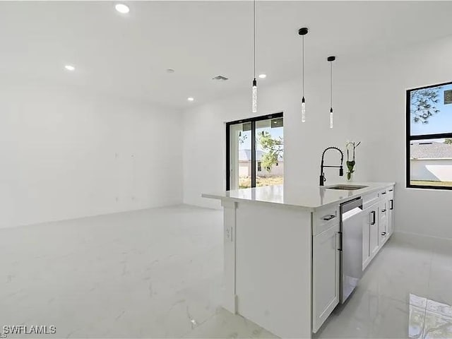 kitchen featuring sink, decorative light fixtures, dishwasher, an island with sink, and white cabinets