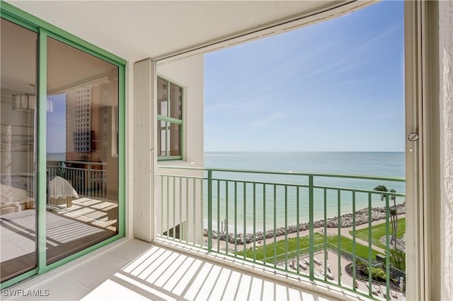 balcony with a water view and a beach view