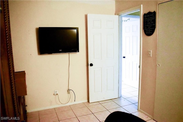 unfurnished bedroom featuring light tile patterned flooring and baseboards