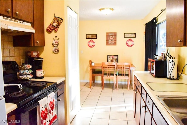 kitchen featuring light tile patterned floors, electric range, decorative backsplash, light countertops, and under cabinet range hood