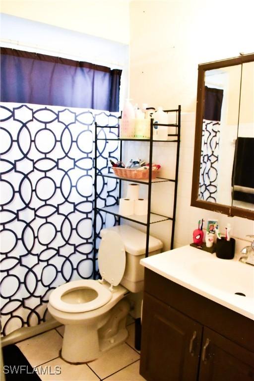 full bathroom featuring toilet, vanity, and tile patterned floors