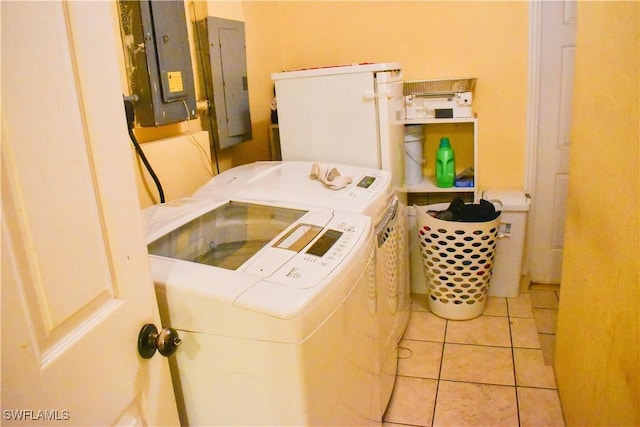 washroom featuring laundry area, washing machine and dryer, electric panel, and light tile patterned floors