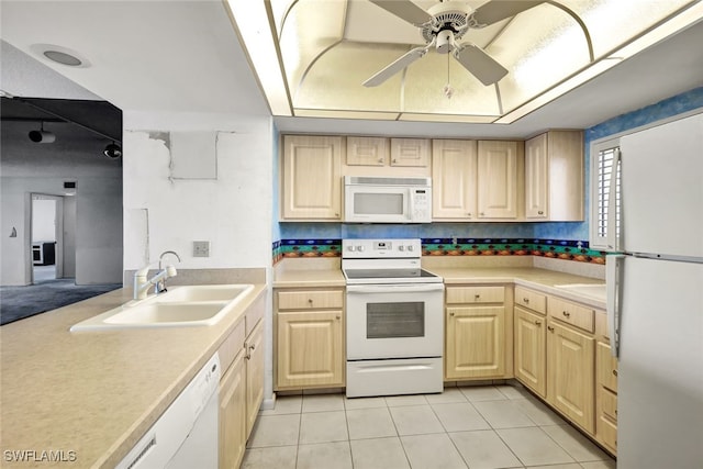 kitchen featuring sink, white appliances, light brown cabinets, a tray ceiling, and ceiling fan