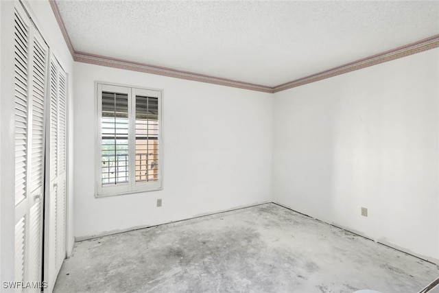 spare room with ornamental molding and a textured ceiling