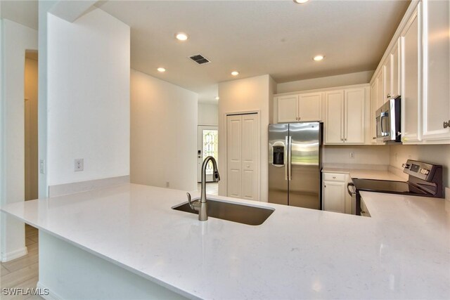2591 Vine Ave, Naples, FL 34120 - kitchen featuring sink, stainless steel appliances, kitchen peninsula, and white cabinets