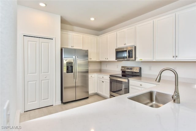 2591 Vine Ave, Naples, FL 34120 - kitchen with white cabinetry, sink, light hardwood / wood-style flooring, and appliances with stainless steel finishes