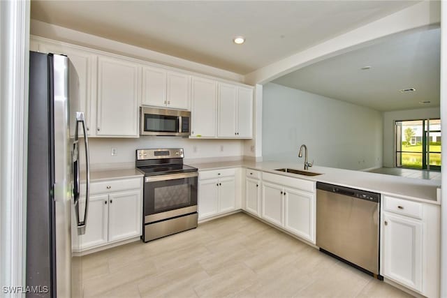 2591 Vine Ave, Naples, FL 34120 - kitchen with white cabinetry, appliances with stainless steel finishes, kitchen peninsula, and sink
