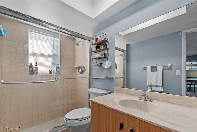 full bathroom with a stall shower, vanity, and toilet