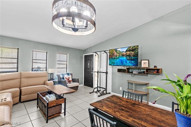 living room with vaulted ceiling, light tile patterned flooring, a notable chandelier, and baseboards