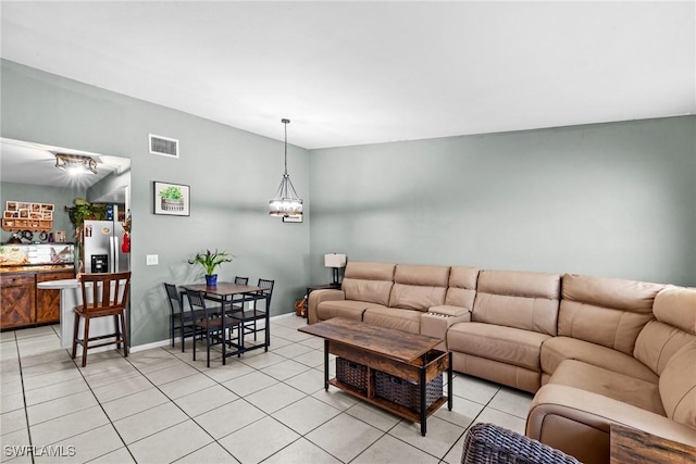 living room featuring visible vents, a notable chandelier, baseboards, and light tile patterned floors