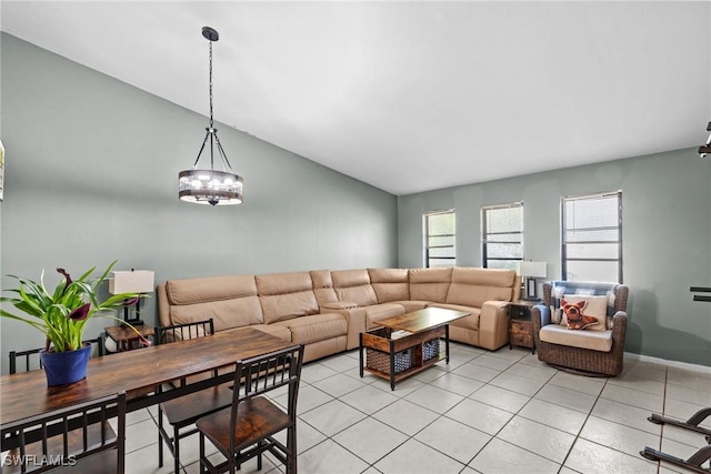 living area featuring vaulted ceiling, light tile patterned floors, and baseboards