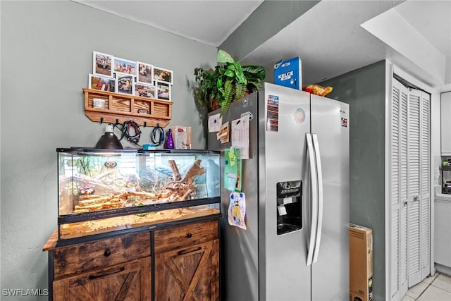 kitchen with light tile patterned flooring and stainless steel fridge