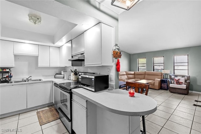 kitchen featuring a peninsula, stainless steel appliances, light countertops, white cabinetry, and a sink