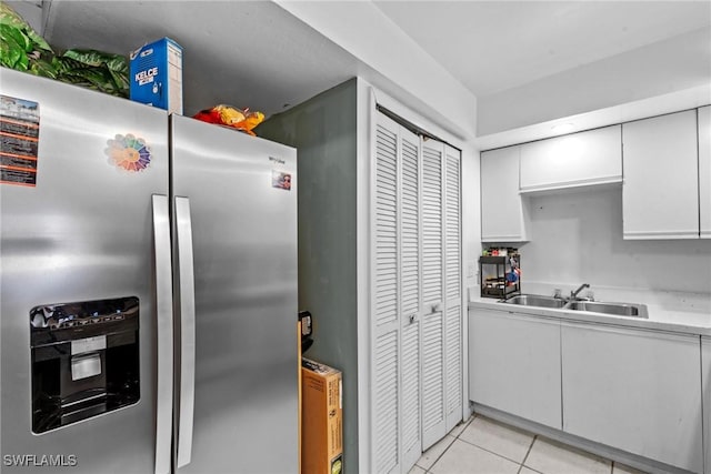 kitchen featuring light tile patterned floors, a sink, white cabinets, light countertops, and stainless steel refrigerator with ice dispenser