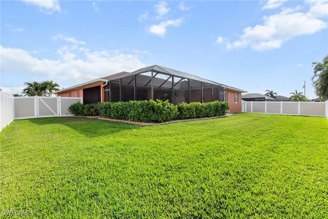 view of yard with a lanai and a fenced backyard