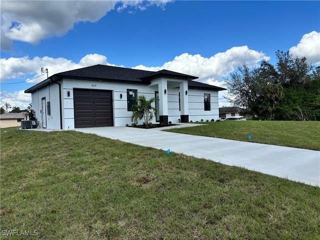 view of front of home with a garage, a front yard, and cooling unit