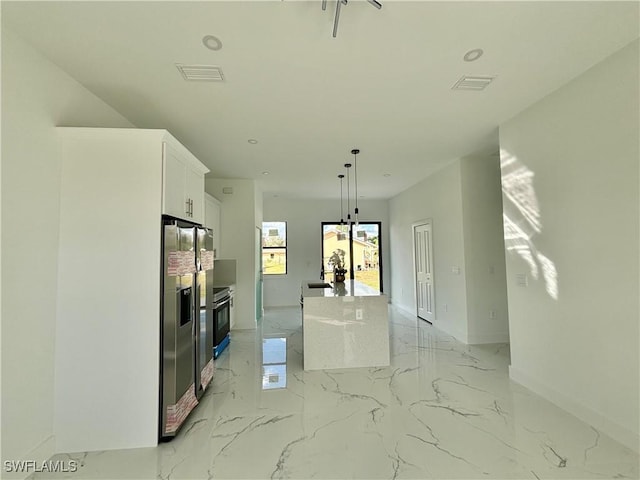 kitchen featuring stainless steel refrigerator with ice dispenser, sink, a center island, pendant lighting, and white cabinets