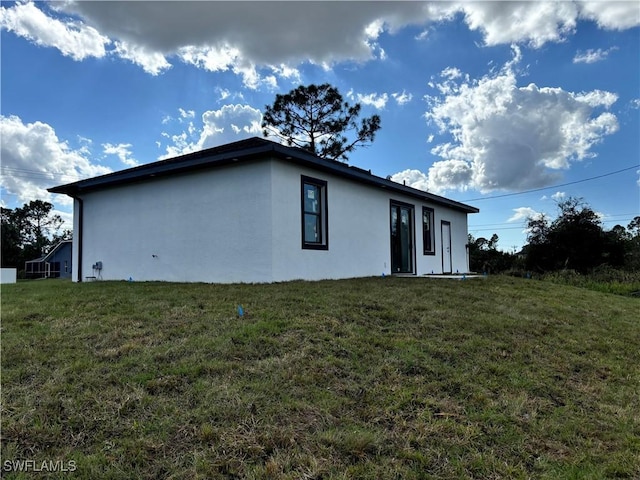 view of side of home with a yard