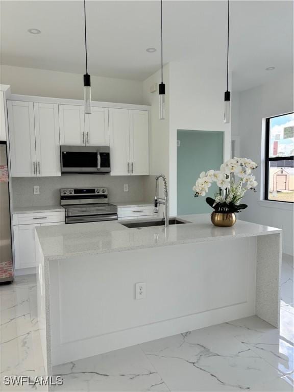 kitchen with pendant lighting, white cabinets, and appliances with stainless steel finishes