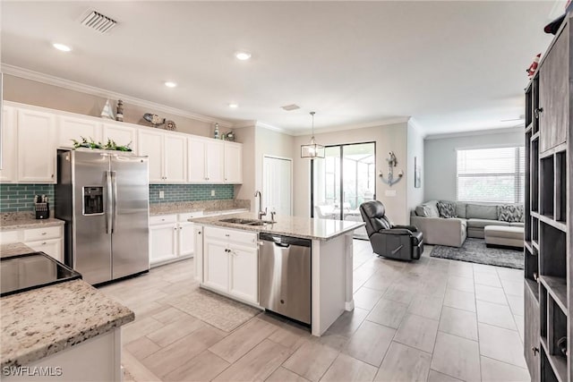 kitchen featuring appliances with stainless steel finishes, sink, a center island with sink, and white cabinets