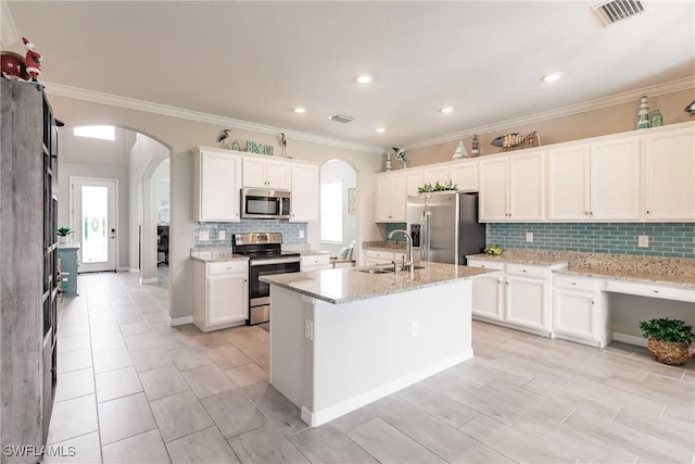 kitchen featuring appliances with stainless steel finishes, sink, a center island with sink, and white cabinets