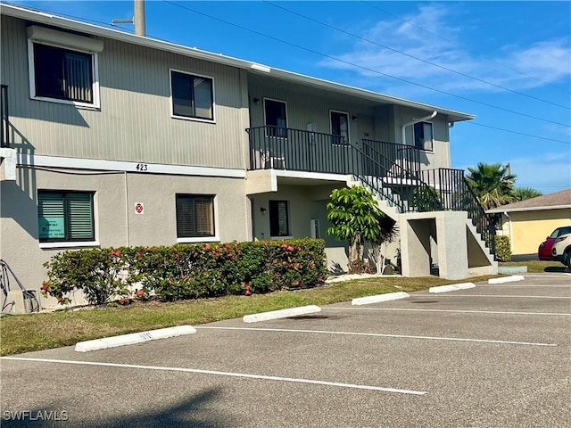 view of building exterior with uncovered parking and stairs