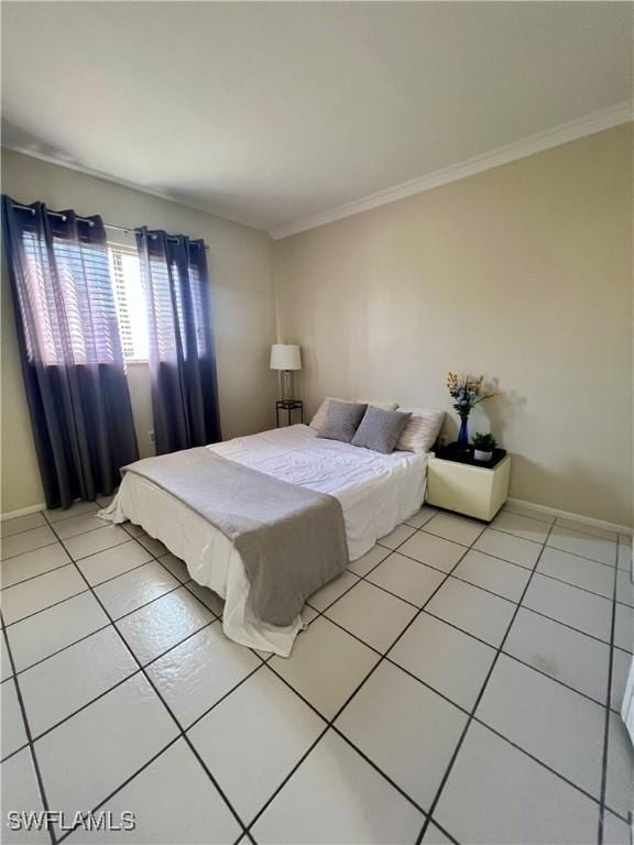 bedroom featuring ornamental molding, tile patterned flooring, and baseboards