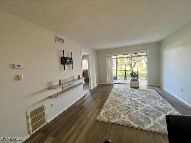 interior space featuring dark wood-style floors, visible vents, and a textured ceiling