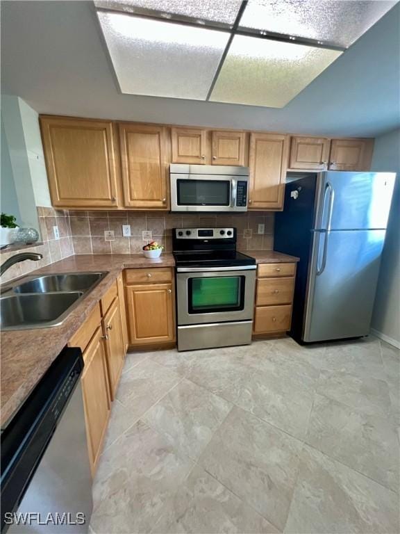 kitchen featuring decorative backsplash, stainless steel appliances, and a sink