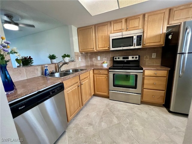 kitchen with ceiling fan, light brown cabinets, a sink, appliances with stainless steel finishes, and backsplash