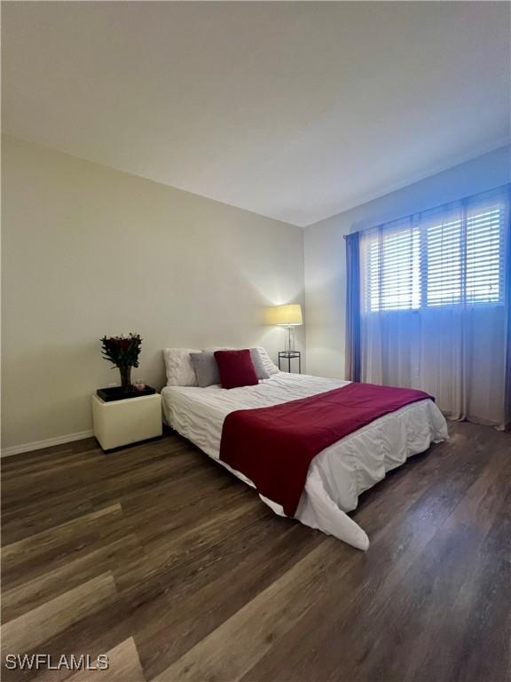 bedroom with dark wood finished floors and baseboards