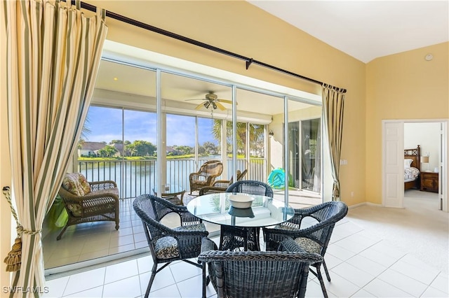 tiled dining room with a water view and ceiling fan