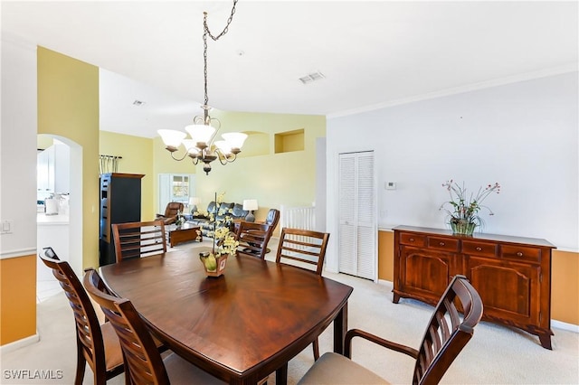 carpeted dining room featuring a notable chandelier and vaulted ceiling