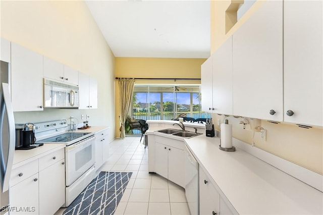 kitchen featuring sink, light tile patterned floors, white cabinets, and white appliances