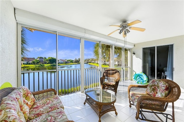 sunroom featuring a water view and ceiling fan