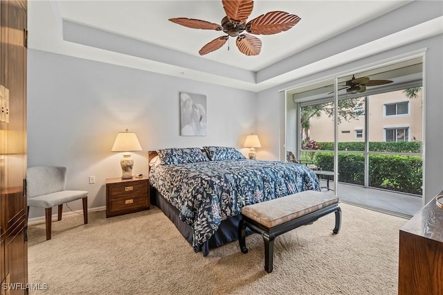 carpeted bedroom featuring ceiling fan, a tray ceiling, and access to outside